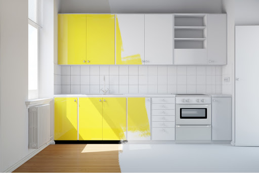 A modern home kitchen with half of the cabinets painted yellow and the other half unpainted.