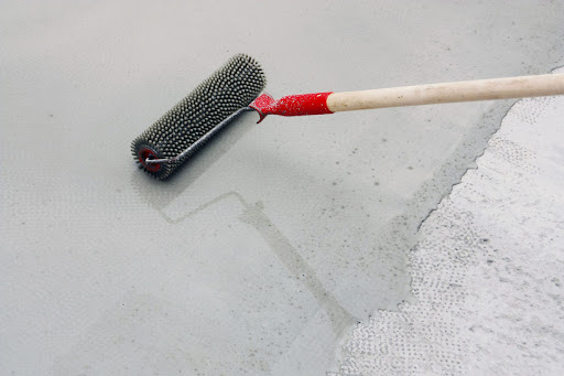 Person applying a fresh coat of paint to a garage floor